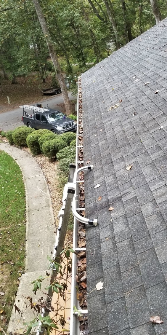 Before — Gutter Guards — debris-packed gutters cleared and fitted with guards.