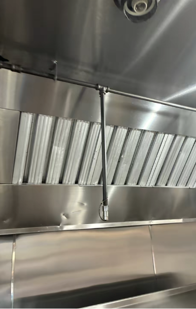 After — Hood canopy and baffle filters — full cook-line hood cleaned and polished.