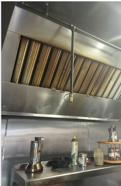 Before — Hood canopy and baffle filters — full cook-line hood cleaned and polished.