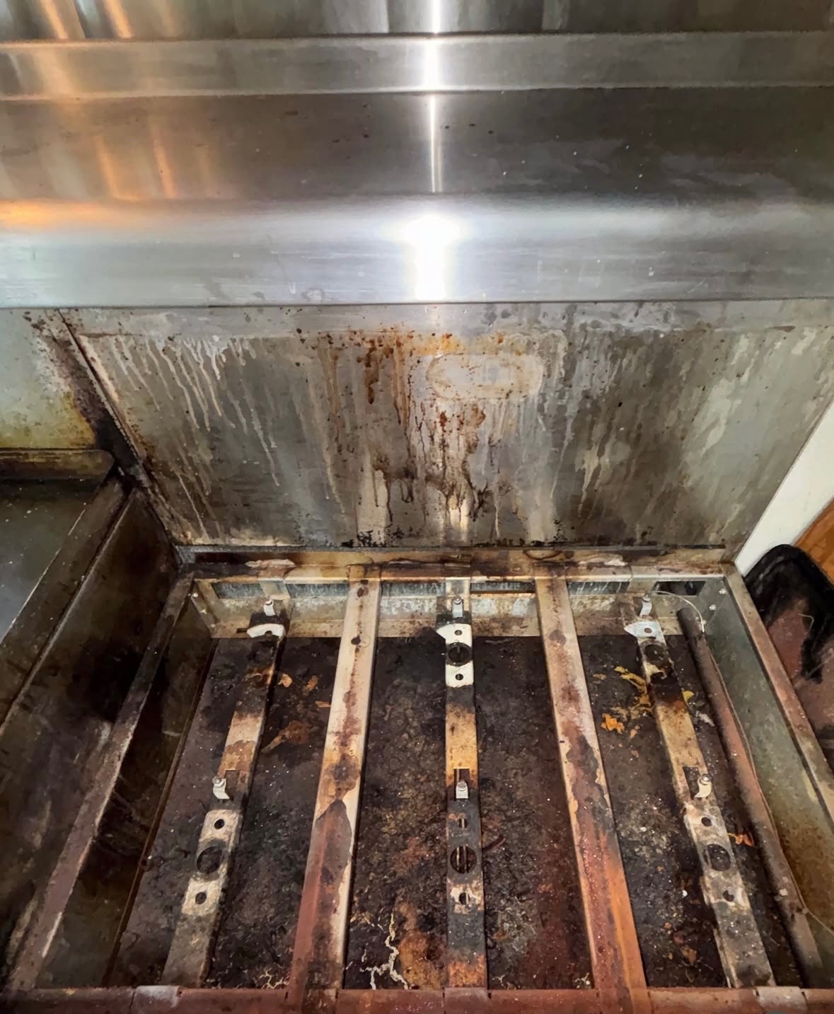 Before — Commercial charbroiler — burners, grates, and grease-caked interior scraped and degreased.